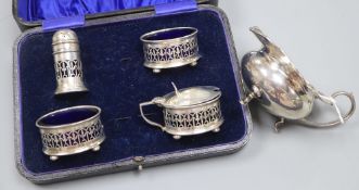 A cased four piece silver cruet set, Birmingham 1921, blue glass liners and a silver milk jug, 3.