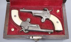A cased pair of pin-fire muff pistols, late 19th/early 20th century, each barrel crudely stamped LC,