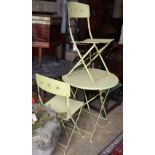 A folding painted circular garden table, 69cm diameter and pair of folding chairs