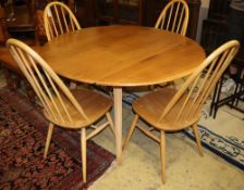 An Ercol circular elm and beech drop leaf dining table, 110cm diameter and four Ercol Windsor