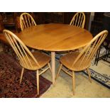 An Ercol circular elm and beech drop leaf dining table, 110cm diameter and four Ercol Windsor