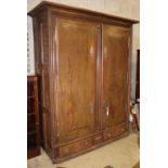 An 18th century Normandy oak two door armoire with brass escutcheons and buttressed hinges, W.178cm,