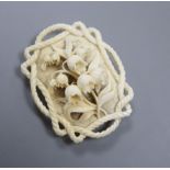 A 19th century Dieppe ivory pendant, carved with lily of the valley