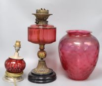 A cranberry oil lamp and shade, 49cm excl. shade, and a small cranberry table lamp