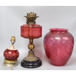 A cranberry oil lamp and shade, 49cm excl. shade, and a small cranberry table lamp