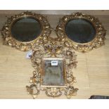 A pair of Venetian circular carved giltwood wall mirrors and another similar mirror