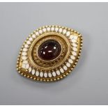 An Etruscan Revival yellow metal, white enamel and garnet navette-shaped brooch with glazed back