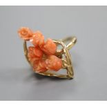 A carved coral mounted ring, stamped '585', finger size M/N