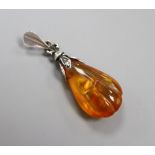 A silver and amber pendant with inclusions,