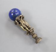 A bronze desk seal modelled as three putti on a pillar mounted with a lapis lazuli, total length 9.