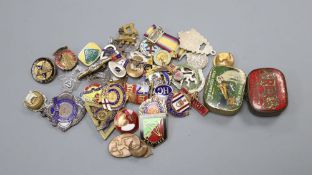 A collection of 20th century badges and two tins of gramophone needles