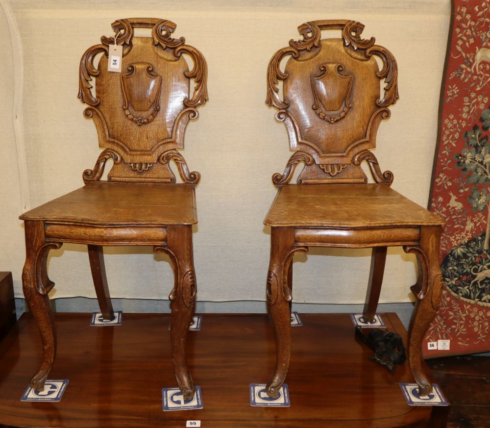 A pair of Victorian oak hall chairs