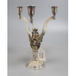 A silver parcel gilt three branch candelabra, shaped arms, on rampant bat, griffin and eagle