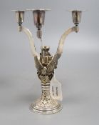 A silver parcel gilt three branch candelabra, shaped arms, on rampant bat, griffin and eagle