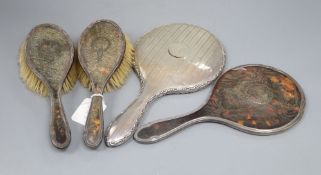 A three piece silver and tortoiseshell backed dressing table set, inset wreath pattern comprising: