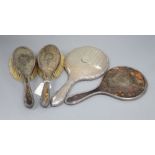 A three piece silver and tortoiseshell backed dressing table set, inset wreath pattern comprising: