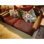 A brown leather Chesterfield two seater settee, with fabric upholstered cushion seats, W.200cm
