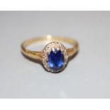 An 18ct, synthetic sapphire and diamond set oval cluster ring, size T, gross 3.2 grams.CONDITION: