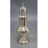 A silver vase shape sugar shaker, with pierced domed cover, ribbed finial on circular base,