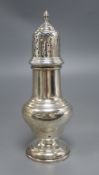 A silver vase shape sugar shaker, with pierced domed cover, ribbed finial on circular base,