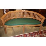 A teak garden banana bench with green cushion seat, W.160cm, D.56cm, H.83cm