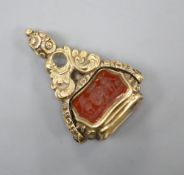 A Victorian yellow metal overlaid swivel triple gem set fob seal, with carved carnelian matrix,