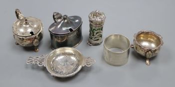 A silver tea strainer, a silver serviette ring and five various silver condiments, 8.95oz (excluding