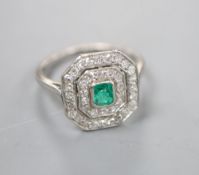 An Art Deco white metal, emerald and diamond set octagonal tablet ring, (emerald chipped), size J/K,