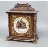 A German ornately carved and brass mounted mantel clock, height 34cm