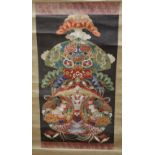 A Japanese scroll decorated with a design of bright multi-coloured motifs creating a central