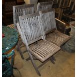 A set of six weathered teak folding garden chairs