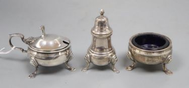 A silver three piece cruet set, with embossed girdle, on three hoof feet, blue glass liners,