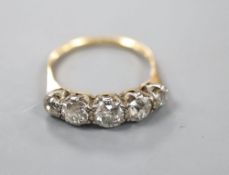 An early 20th century yellow metal and graduated five stone old cut diamond ring, size R, gross 3