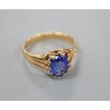 A yellow metal and claw set oval cut sapphire ring, the shank with fluted shoulders, size O/P, gross