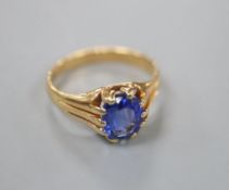 A yellow metal and claw set oval cut sapphire ring, the shank with fluted shoulders, size O/P, gross