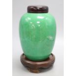 A 19th century Chinese green crackle glaze jar, drilled, wood cover and stand, overall height