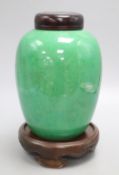 A 19th century Chinese green crackle glaze jar, drilled, wood cover and stand, overall height