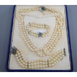 A triple strand cultured pearl necklace and matching bracelet with white metal, emerald and