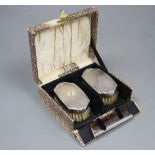 A cased pair of George V silver mounted brushes and matching comb, Birmingham, 1927.