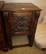 A Tudor style oak cupboard, carved panelled door, on square legs united by stretchers, W.58cm, D.