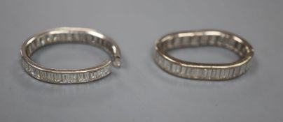 Two white metal and baguette cut diamond set full eternity rings, both very mis-shapen and one shank