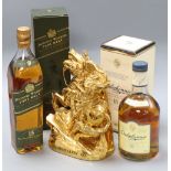 An ornate bottle of Coronation XO cognac and two bottles of whisky
