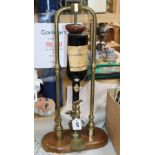 A tubular brass and mahogany wine/port dispenser