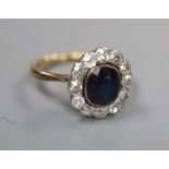 A 1940's/1950's? yellow metal, sapphire and diamond set oval cluster ring, size I/J, gross 3 grams.