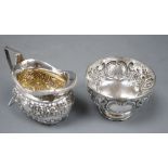 A late Victorian embossed silver sugar bowl, London, 1899 and a later similar cream jug, 6oz.