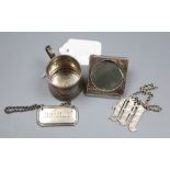 An Edwardian miniature silver mug, a similar photograph frame and two silver wine labels.