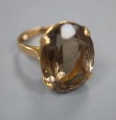 A yellow metal and smoky quartz set oval dress ring, size J, gross 8.9 grams.