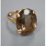 A yellow metal and smoky quartz set oval dress ring, size J, gross 8.9 grams.