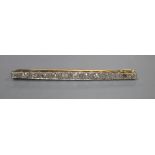 An early 20th century 15ct, plat and graduated thirteen stone diamond set bar brooch, 57mm, gross