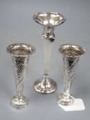 A pair of late Victorian embossed silver spill vases, 13.2cm and a larger silver vase, all